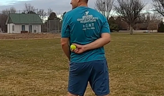 Tennis ball caught behind back from a long distance,