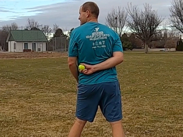 Tennis ball caught behind back from a long distance,