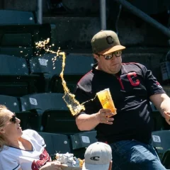 A spectator's attempt to catch a ball at a baseball match cost a woman sitting in the stands a lot of money.