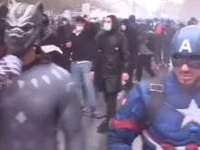 People participate in anti-government protests wearing superhero costumes