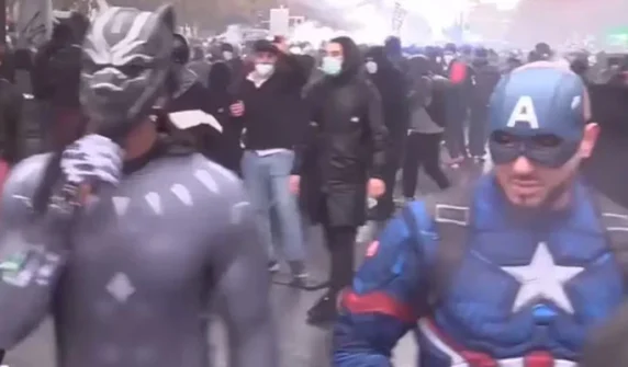 People participate in anti-government protests wearing superhero costumes